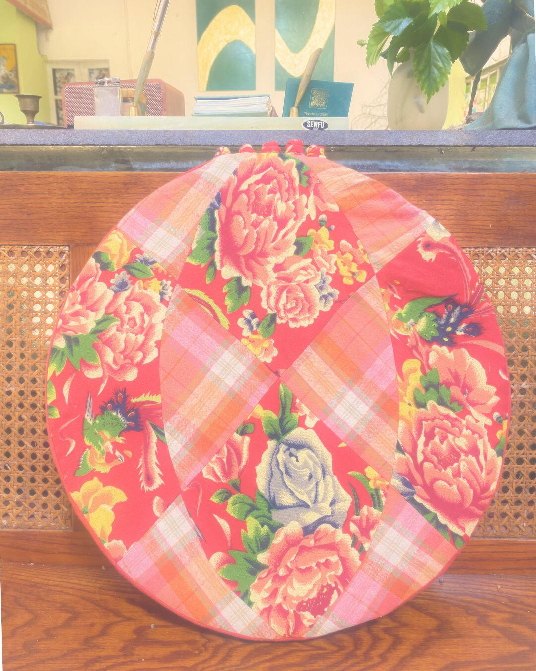Where Balance Forms Circular textile cushion displayed upright against a wooden bench.