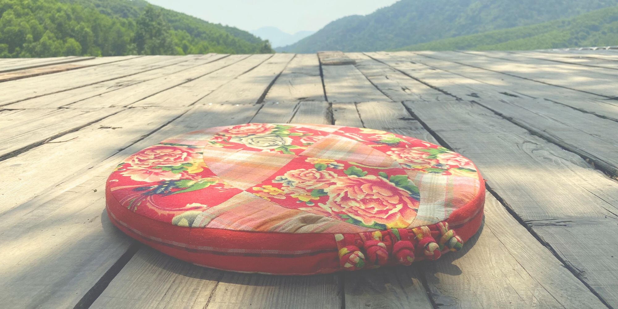 Where Balance Forms - Danang valley Circular textile cushion installed on a wooden platform overlooking a valley in Đà Nẵng.