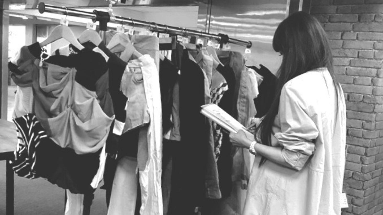 Who's Uniform Jury Review Design juror reviewing reconstructed uniform garments.