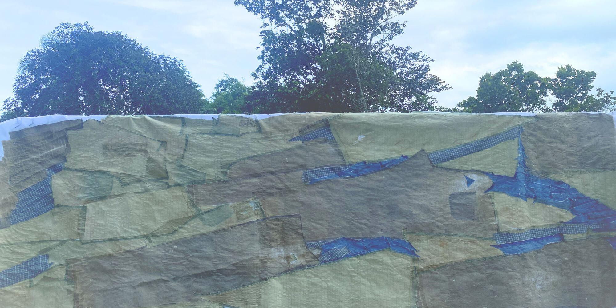 Sky Suspended Suspended textile installation displayed against blue sky and trees.