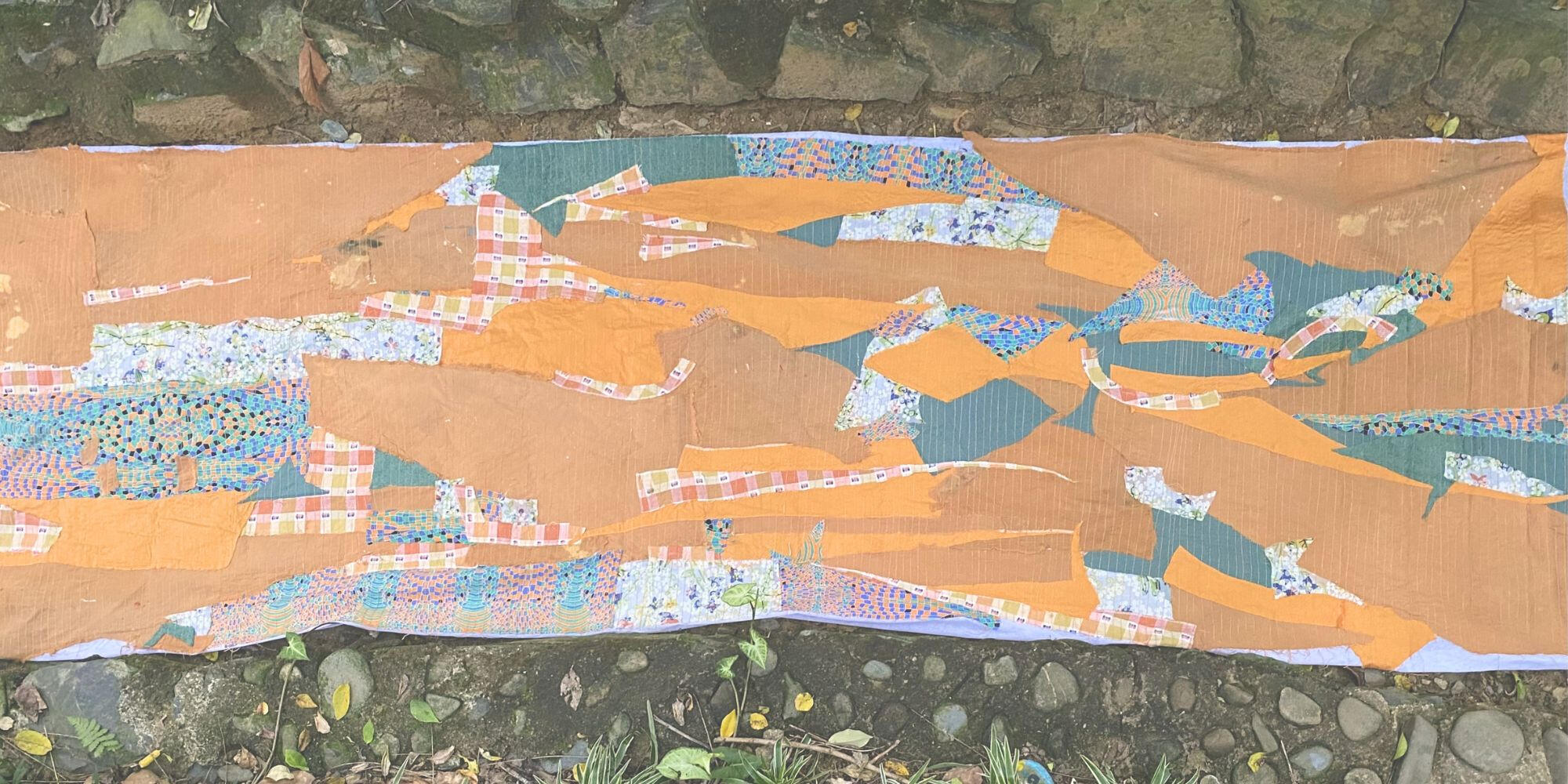 Earth Stone Textile installation laid among stone paving outdoors.